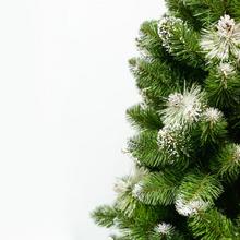 Bílý vánoční stromeček s chocholy.