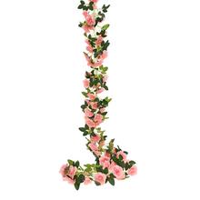Umělá girlanda s růžovými květy a zelenými listy.