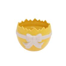 Žlutý a bílý porcelánový obal ve tvaru skořápky.