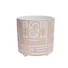 Bílý a zlatý květináč na noze s dekorativním vzorem.