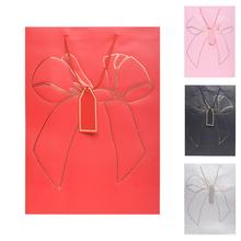 Dárková taška s mašlí v různých barvách.