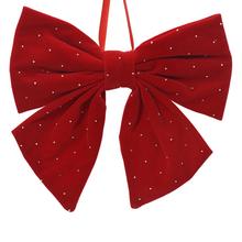 Červená sametová mašle se stříbrnými tečkami.