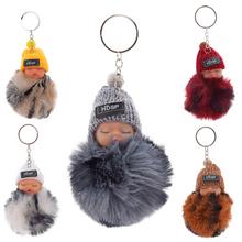 Přívěsek miminko s různými barvami čepic a kožešinou.